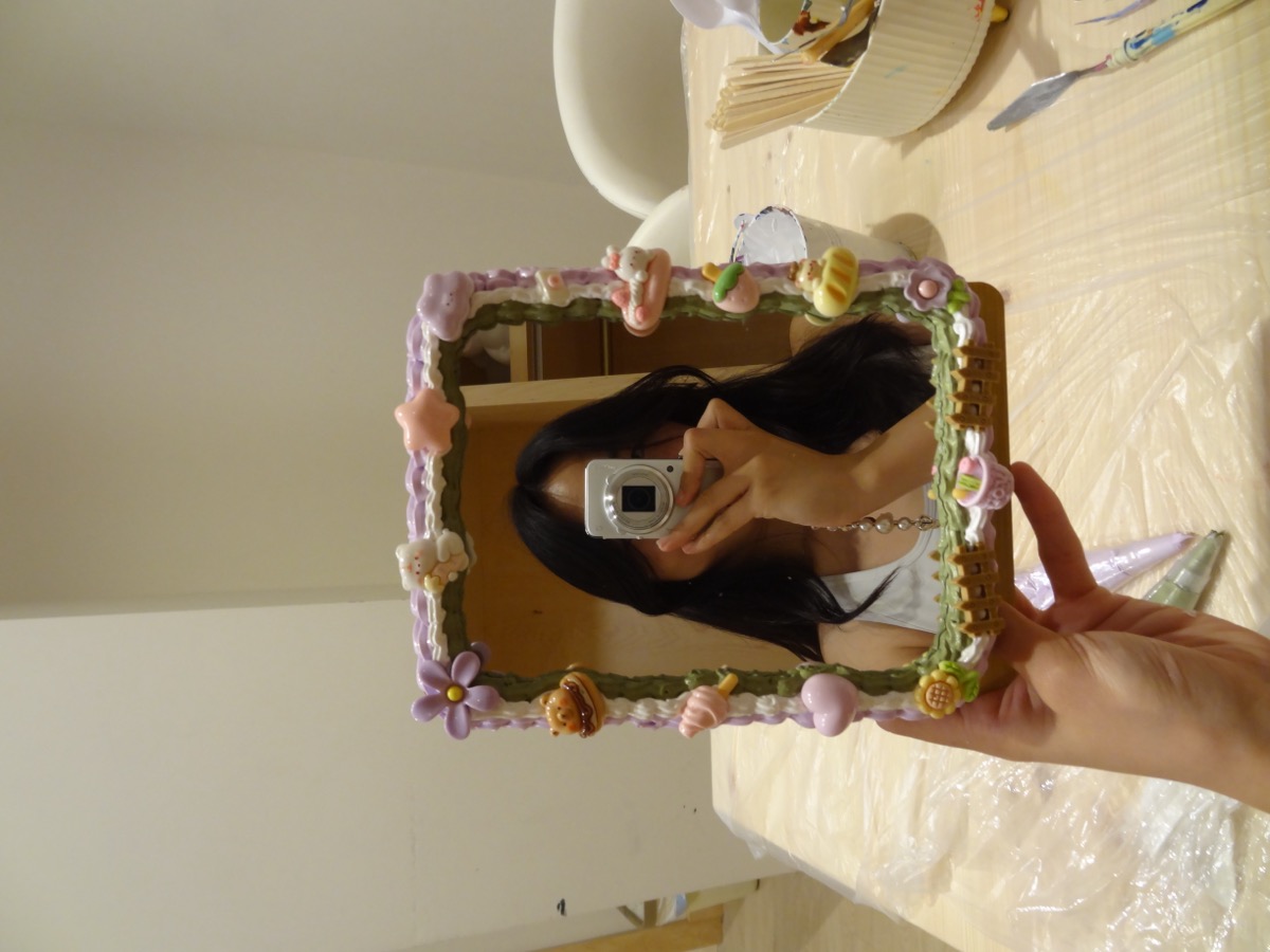 Decorating a colorful mirror during a craft experience